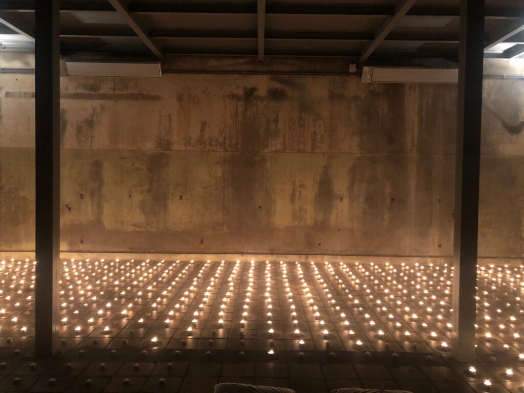 823 waxinelichtjes op de tegelvloer voor de betonwand