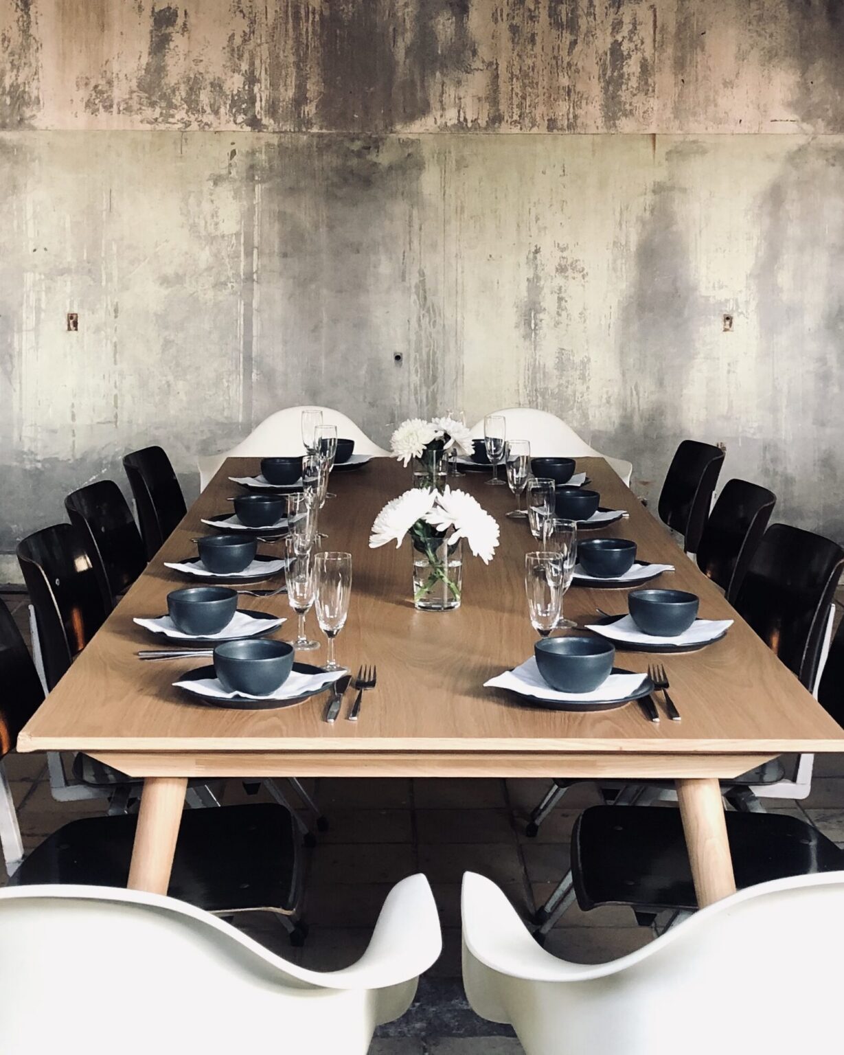Breakfast table set against the concrete wall