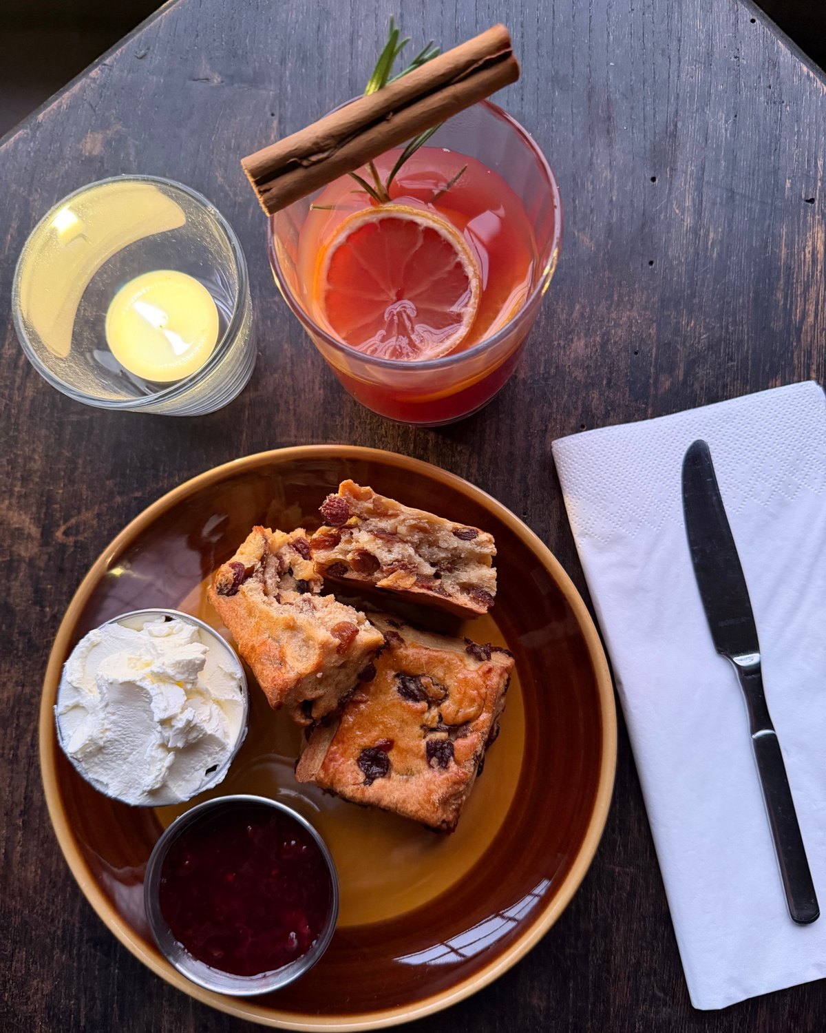 Scone met room en jam, punch en een kaars van bovenaf