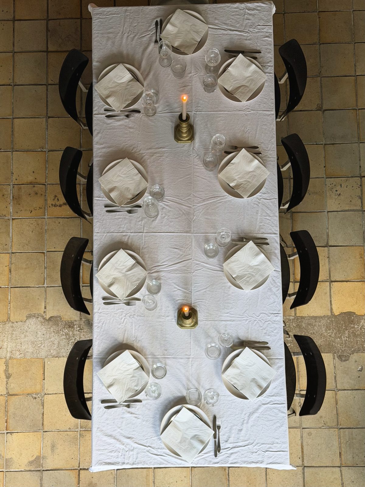 De gedekte lange tafel van bovenaf, op de tegelvloer
